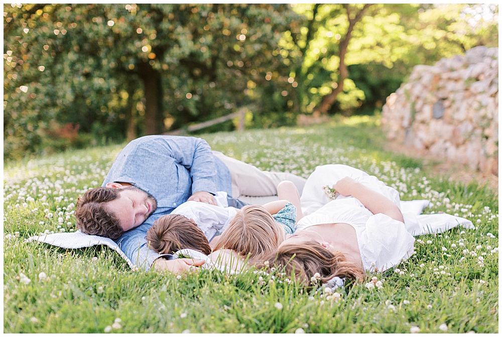 Family lays down together in field