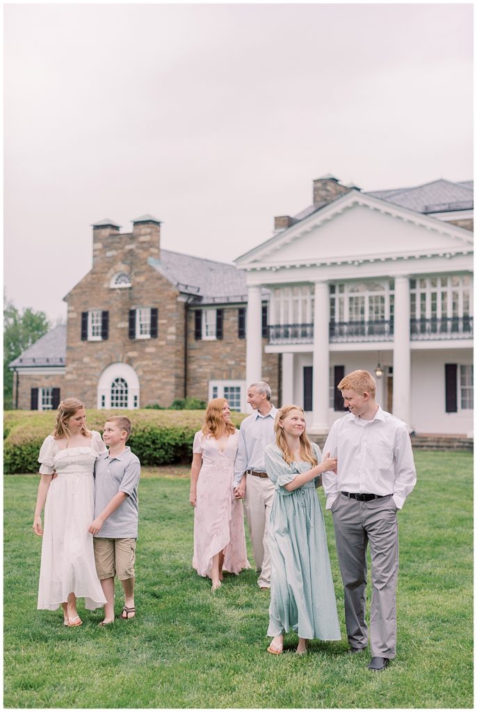 Large family walks together in front of Glenview Mansion during their photo session
