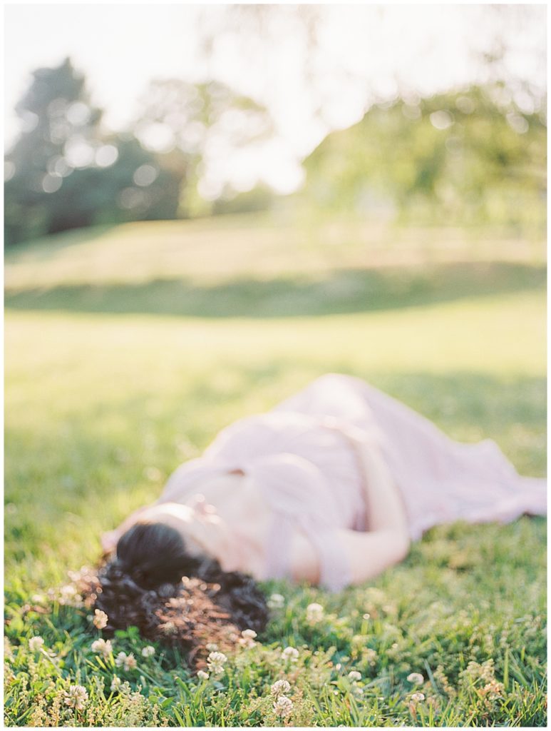 Maryland Maternity Photographer | Pregnant woman lays down in a field