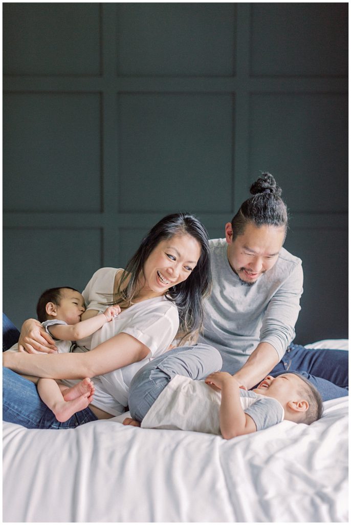 Northern Virginia Lifestyle Photographer | Mother and father play with their sons on the bed.