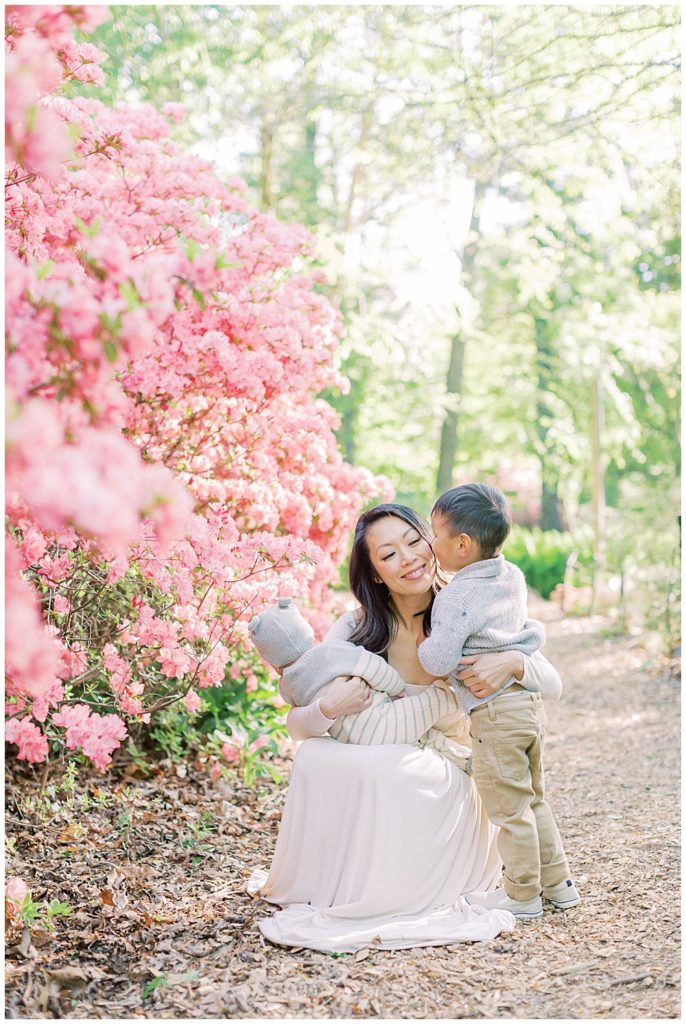 Little boy kisses his mother's cheek by the azaleas at Brookside Gardens in Silver Spring