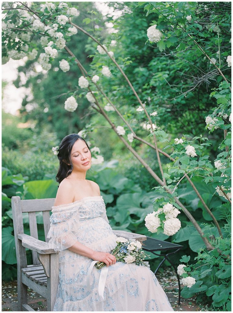 DC Maternity Photographer | Pregnant woman sits on a bench at Tudor Place during maternity session