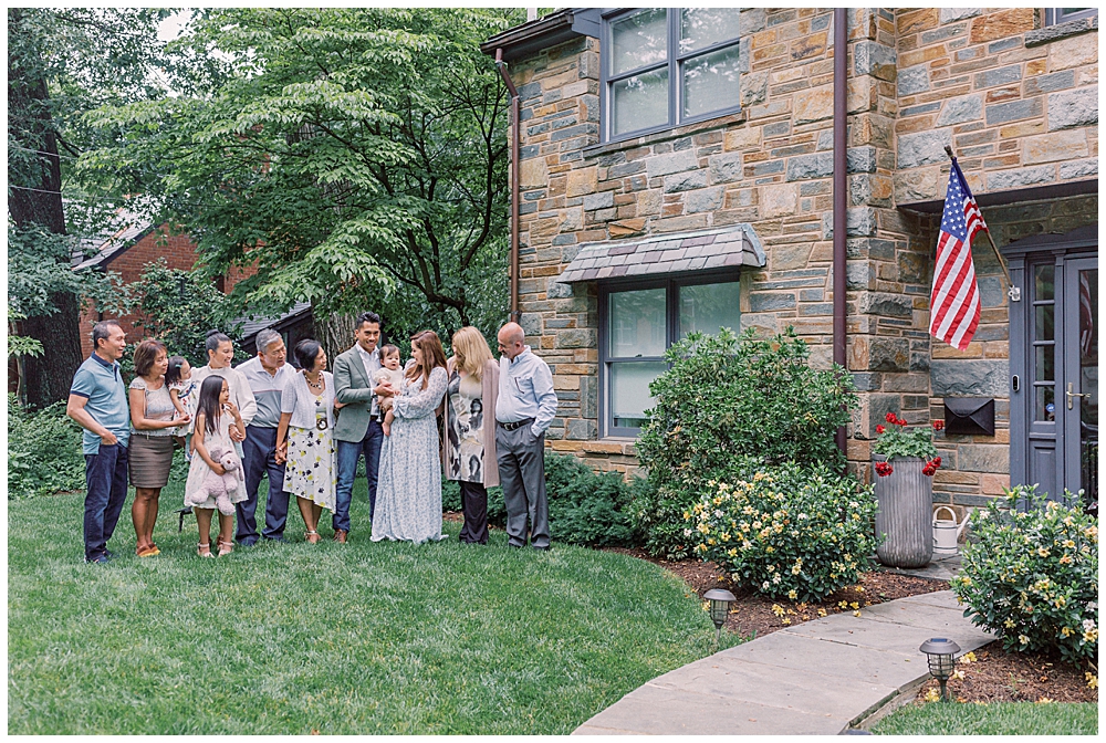 A large family stands in front of their home, celebrating a one year old