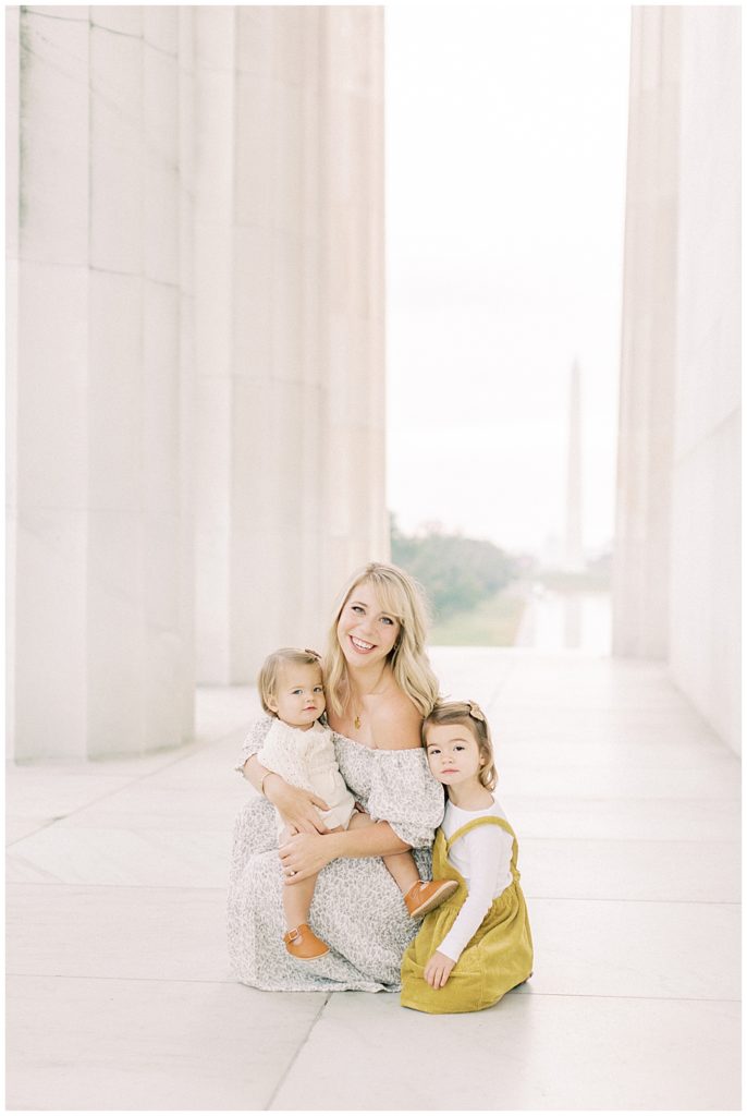 Mother sits with her two daughters in the Lincoln Memorial in Washington DC