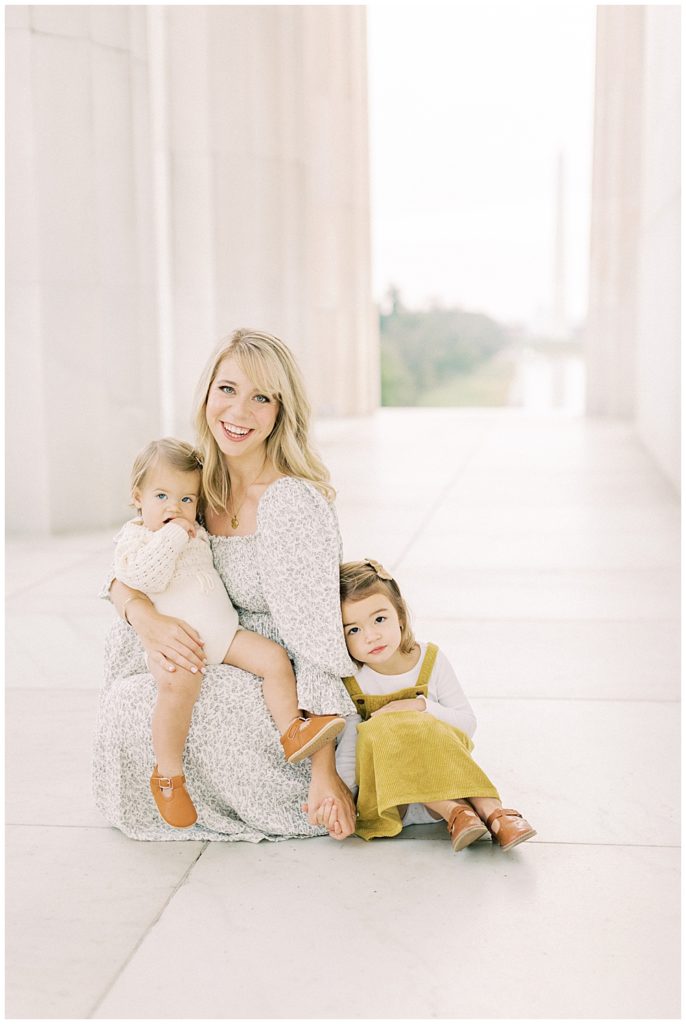 Mother sits with two daughters during DC photo session at the Lincoln Memorial