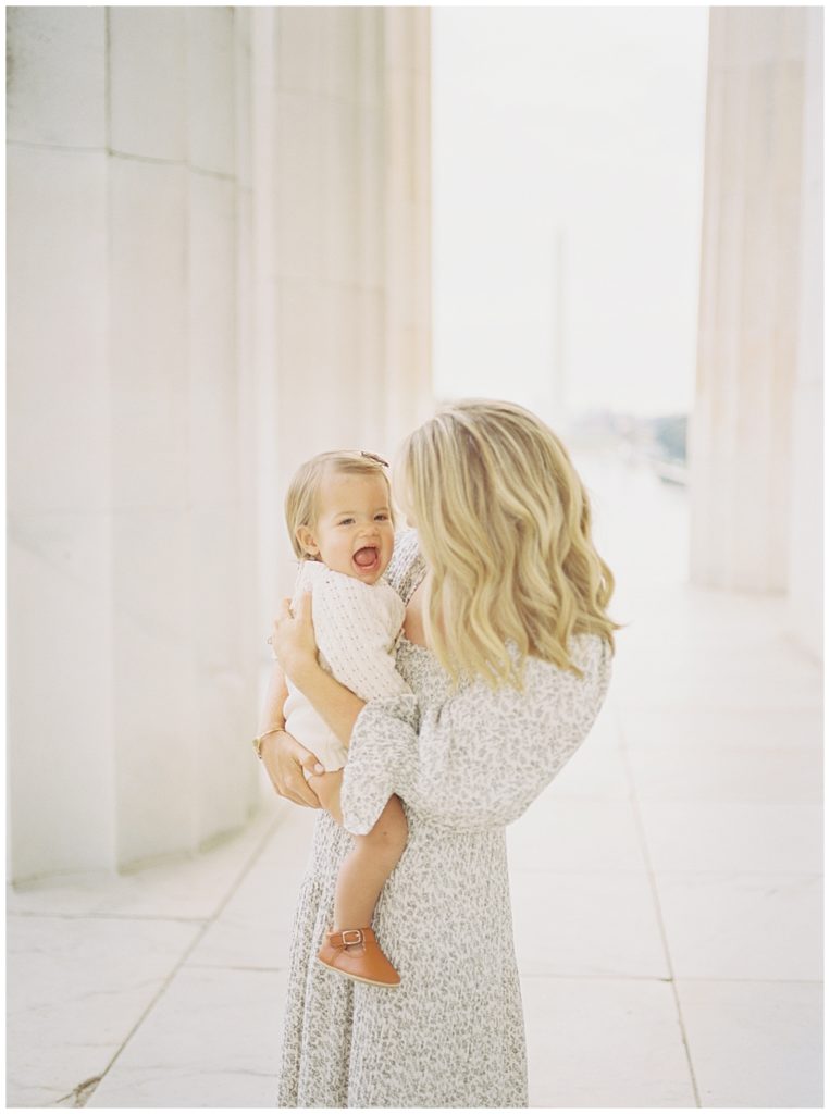Mother holds her baby girl in the Lincoln Memorial