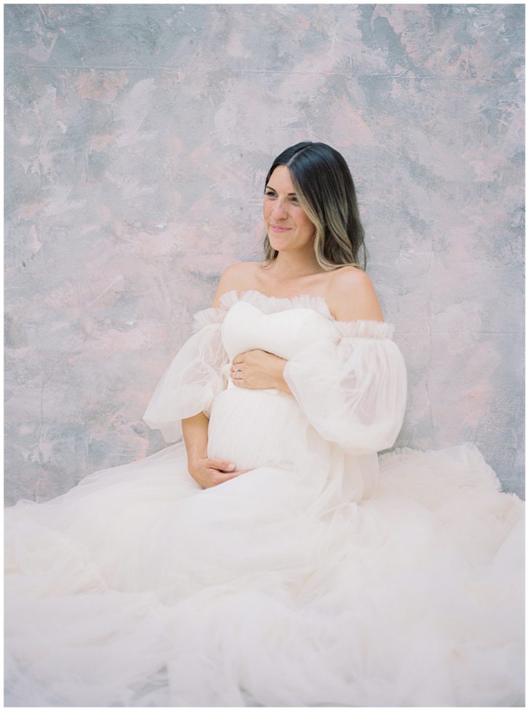 Pregnant mother sits in a DC studio for her maternity session