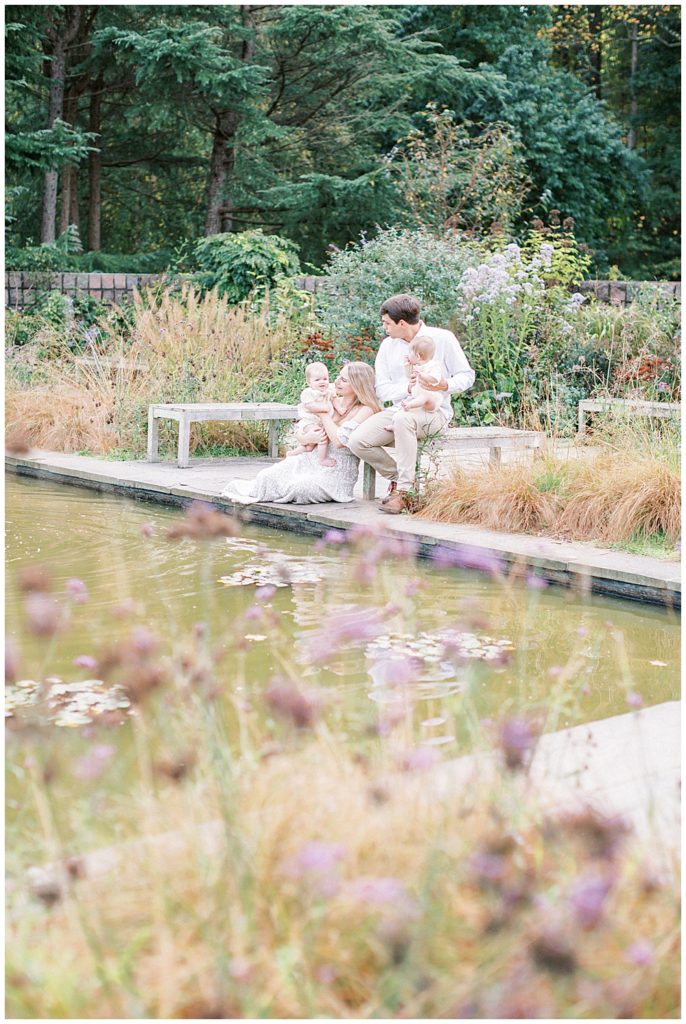 Family sits by a pond in Brookside Gardens