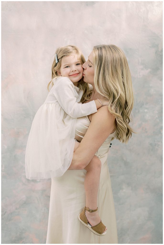 Mother kisses her daughter during their studio session outside of Northern VA