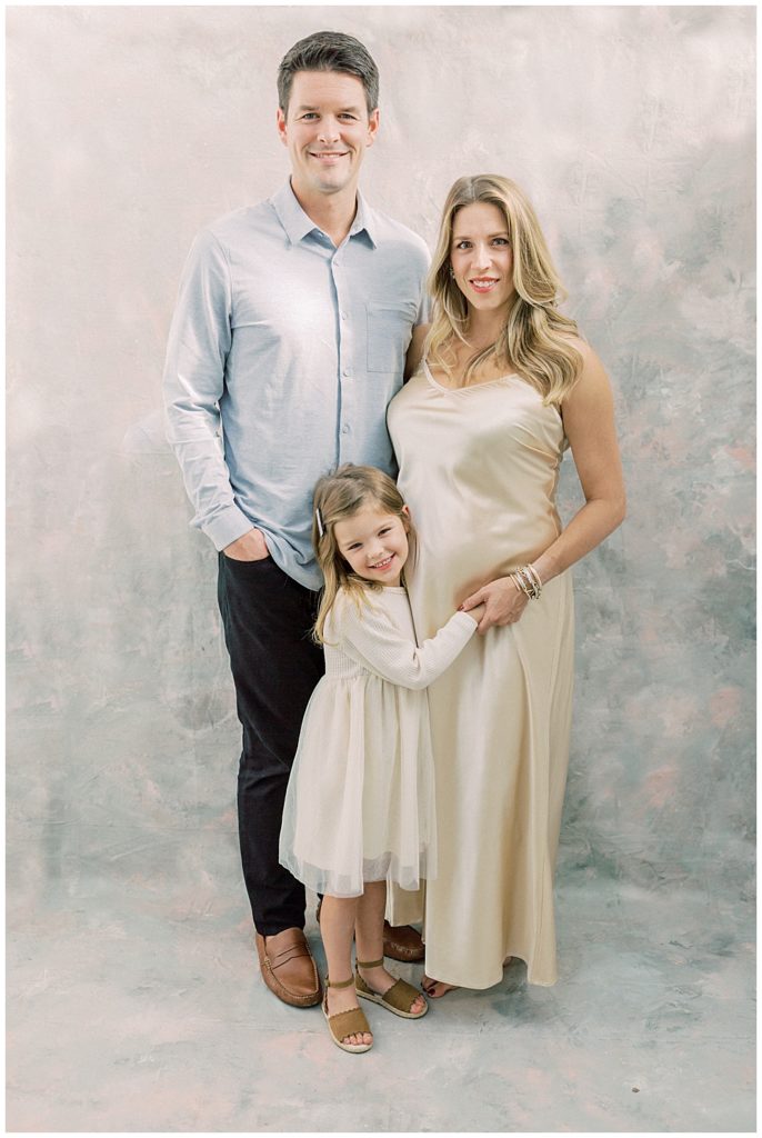 Family photo of mother, father, and little girl during a studio maternity session outside of Northern VA