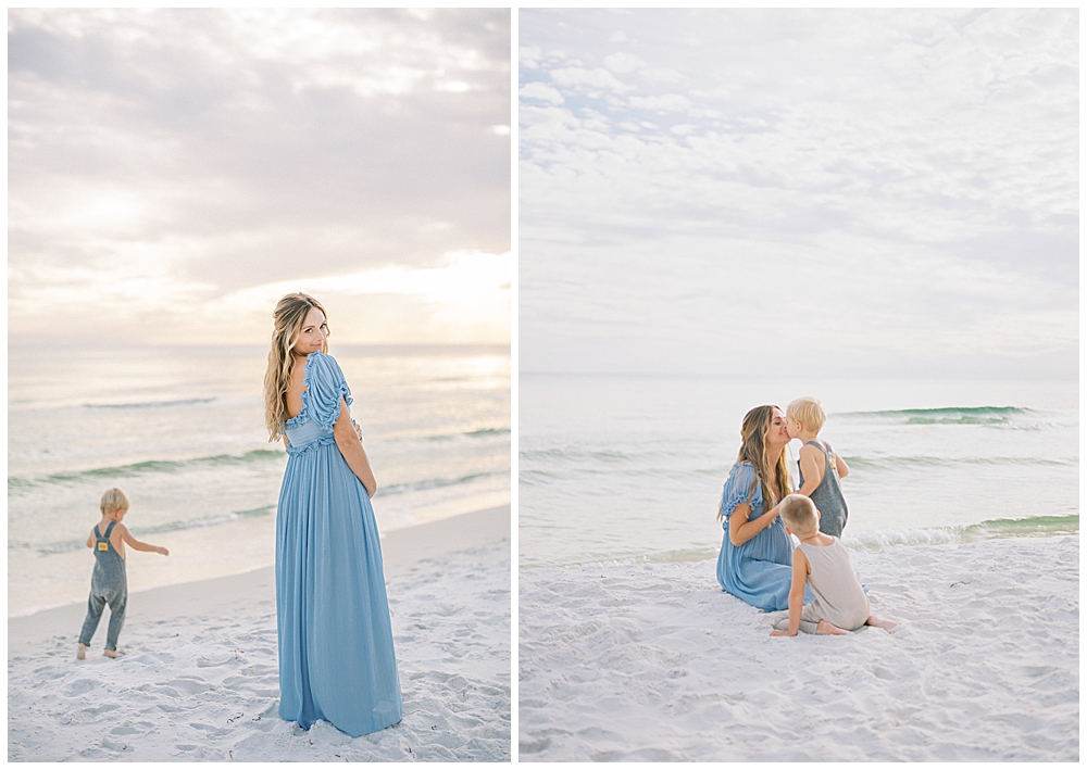 Mother looks over her shoulder while standing on the beach with her young boys during her maternity session