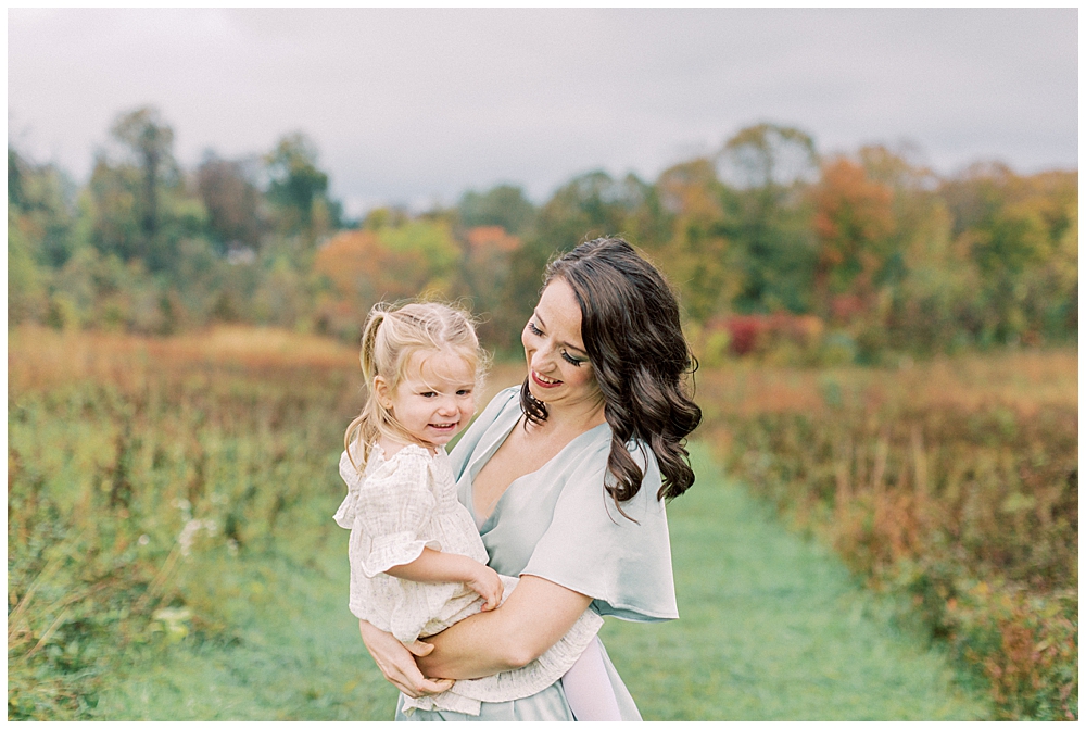 Mother holds her young daughter at the Howard County Conservancy during her family photo session