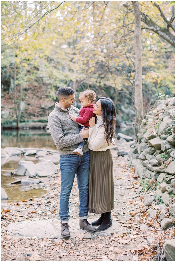 A family stands along a trail in Rock Creek Park in DC while taking family photos