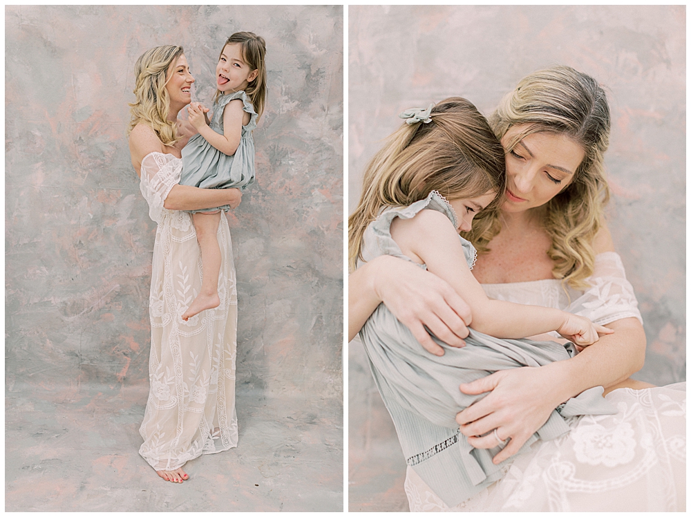 Blonde mother in white dress holds her little girl up close to her