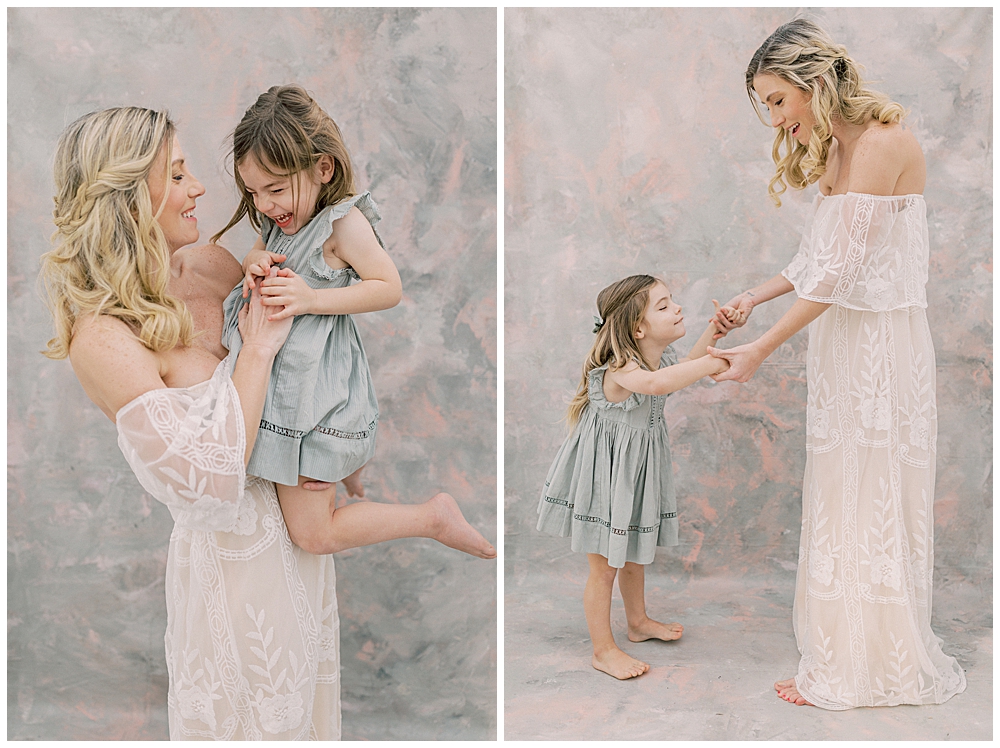 Mother and daughter hold and dance with one another in a studio motherhood session