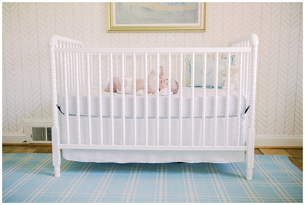 A baby laying in a crib in his nursery