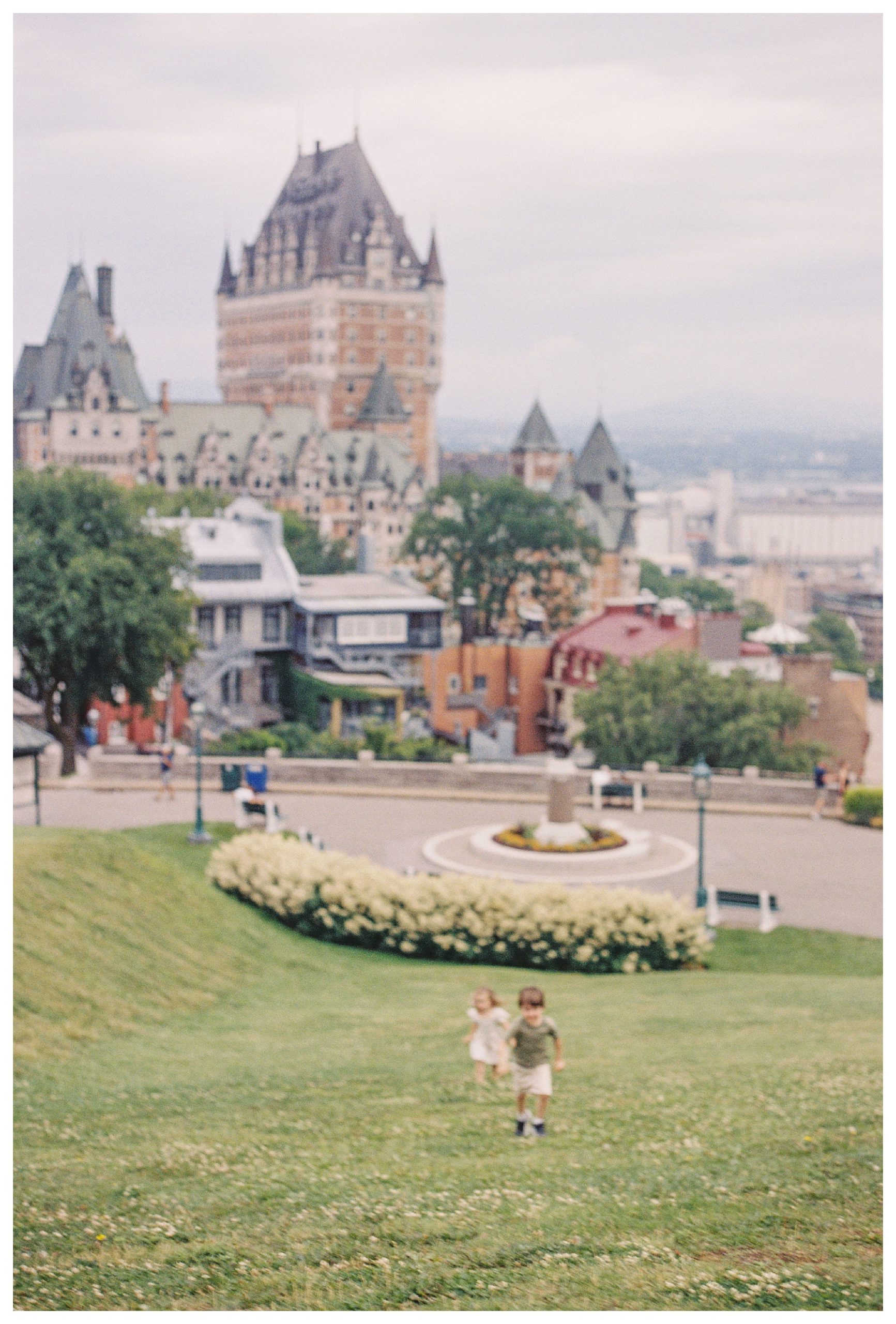 View of children running up hill in front of Fairmont Chateau in Old Quebec City.