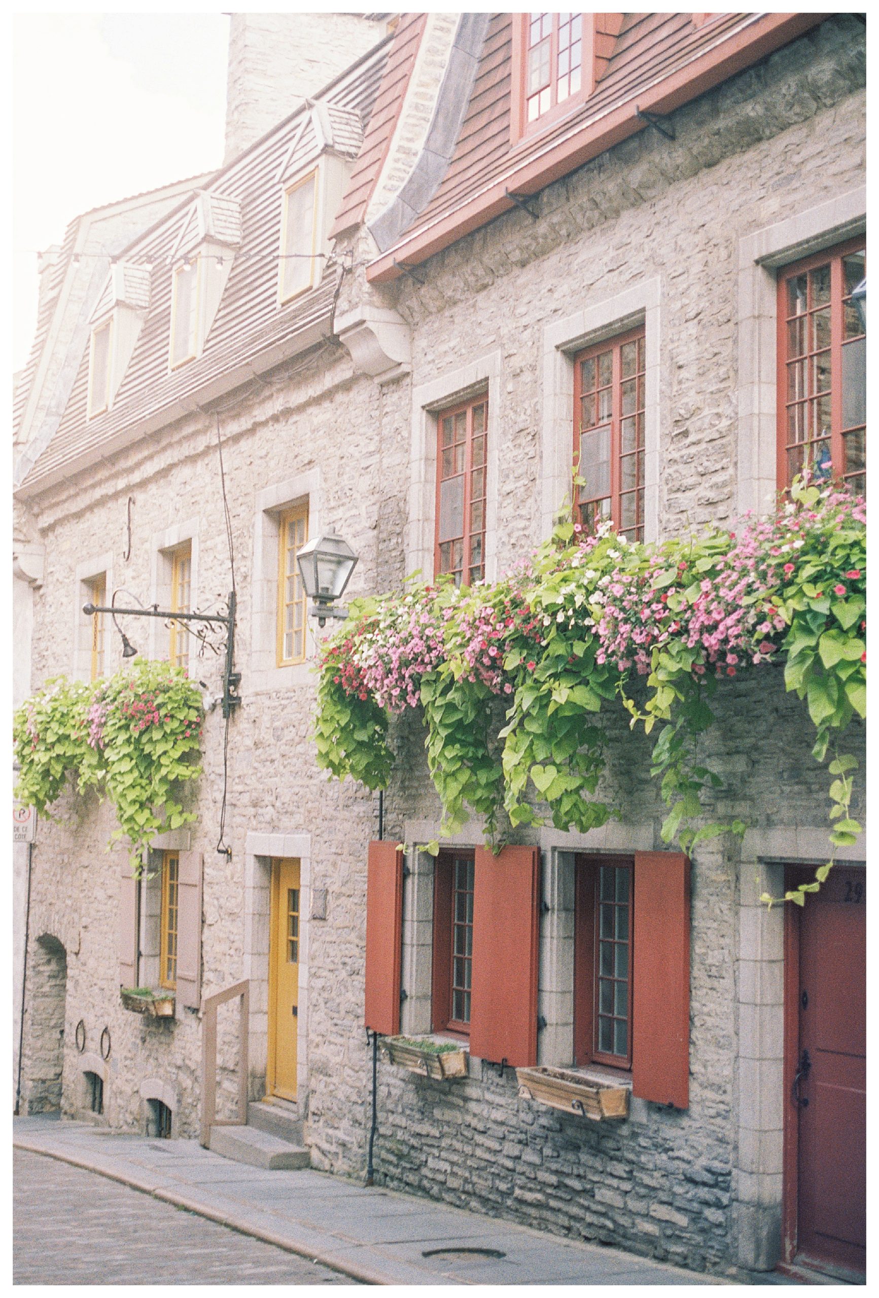 Exterior of old stone buildings with window floral boxes in Quebec City.