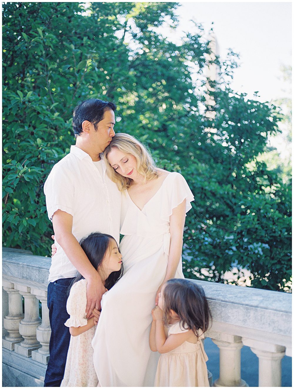 Father kisses his wife's forehead during their DAR Constitution Hall Family photo session.