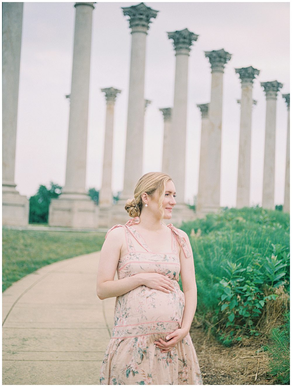 Blonde pregnant mother stands in front of National Arboretum columns during her maternity session.
