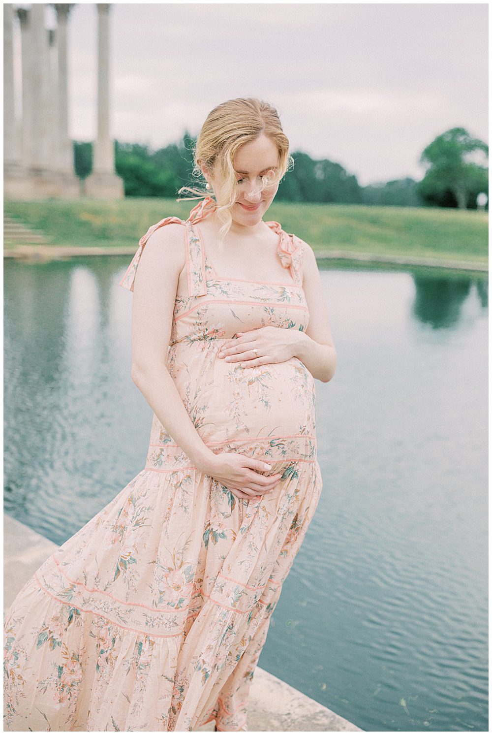 Mother smiles down at her pregnant belly during her National Arboretum maternity session.
