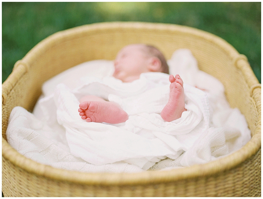 Newborn feet laying in a Moses basket during an outdoor newborn session