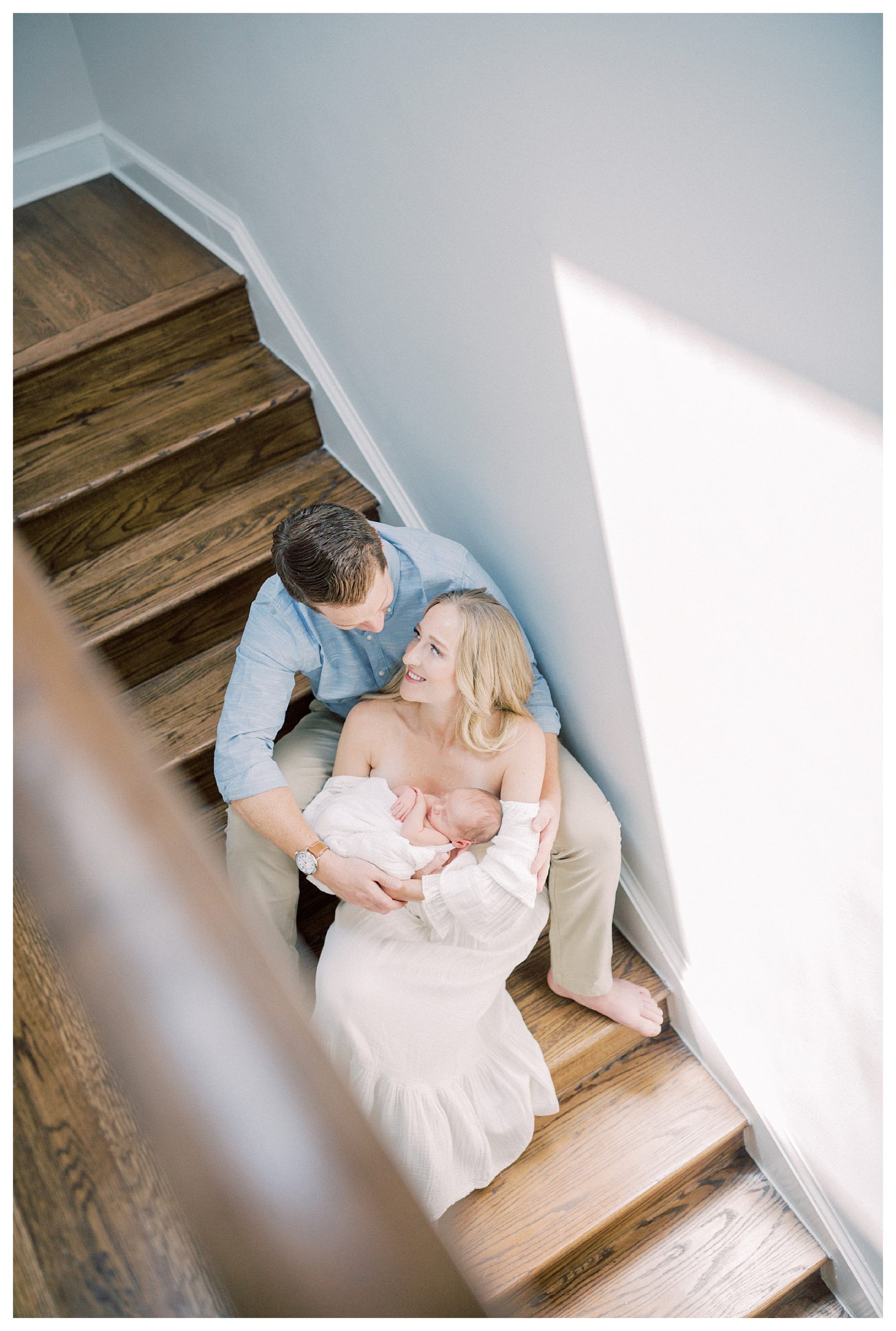 New parents sit on their steps holding newborn baby during their DC newborn session.