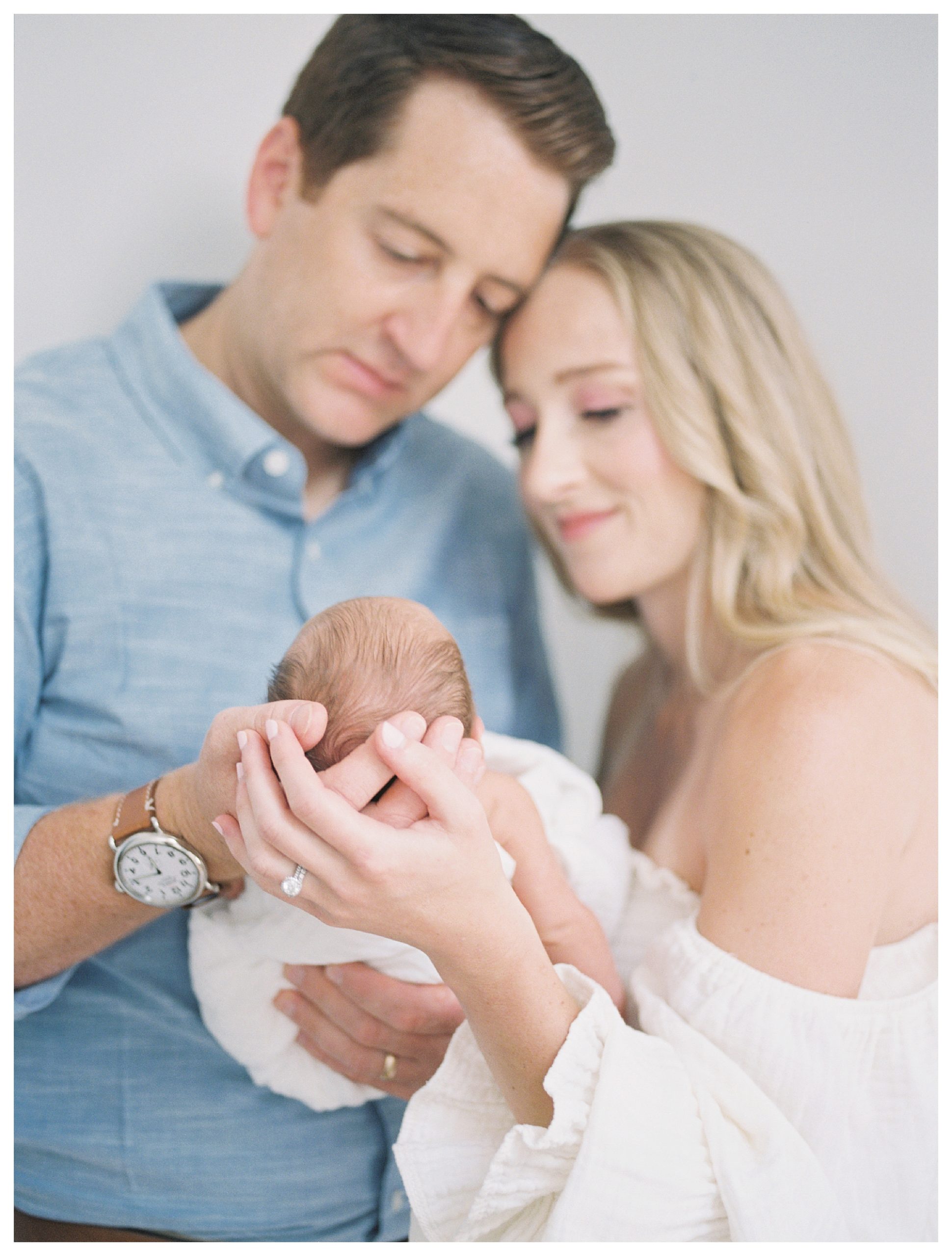 Newborn baby held by admiring mother and father during DC newborn session.