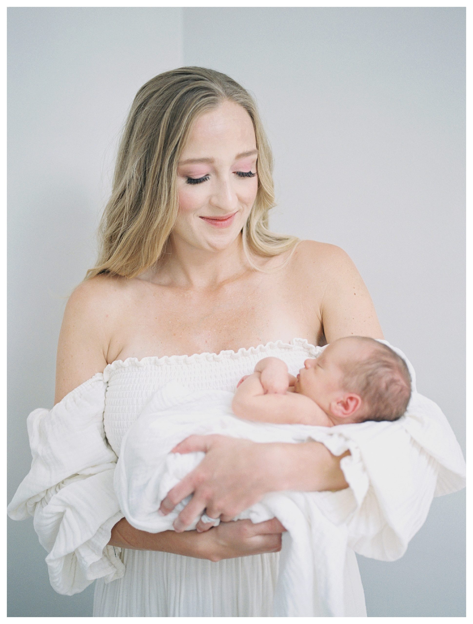 Blonde mother holds her newborn baby boy during her DC newborn session on Capital Hill.