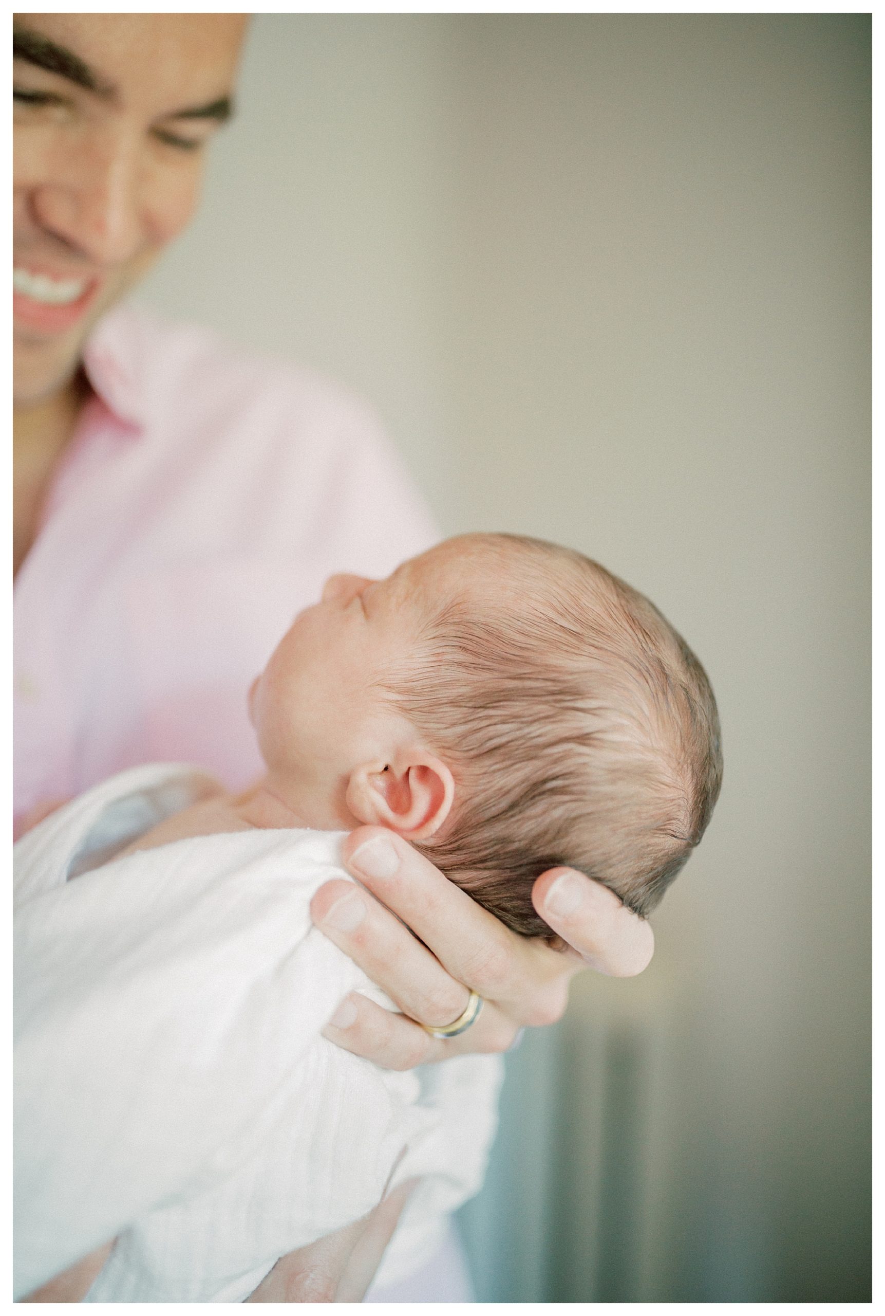 Close-up view of newborn's ears and hair during in-home newborn session.