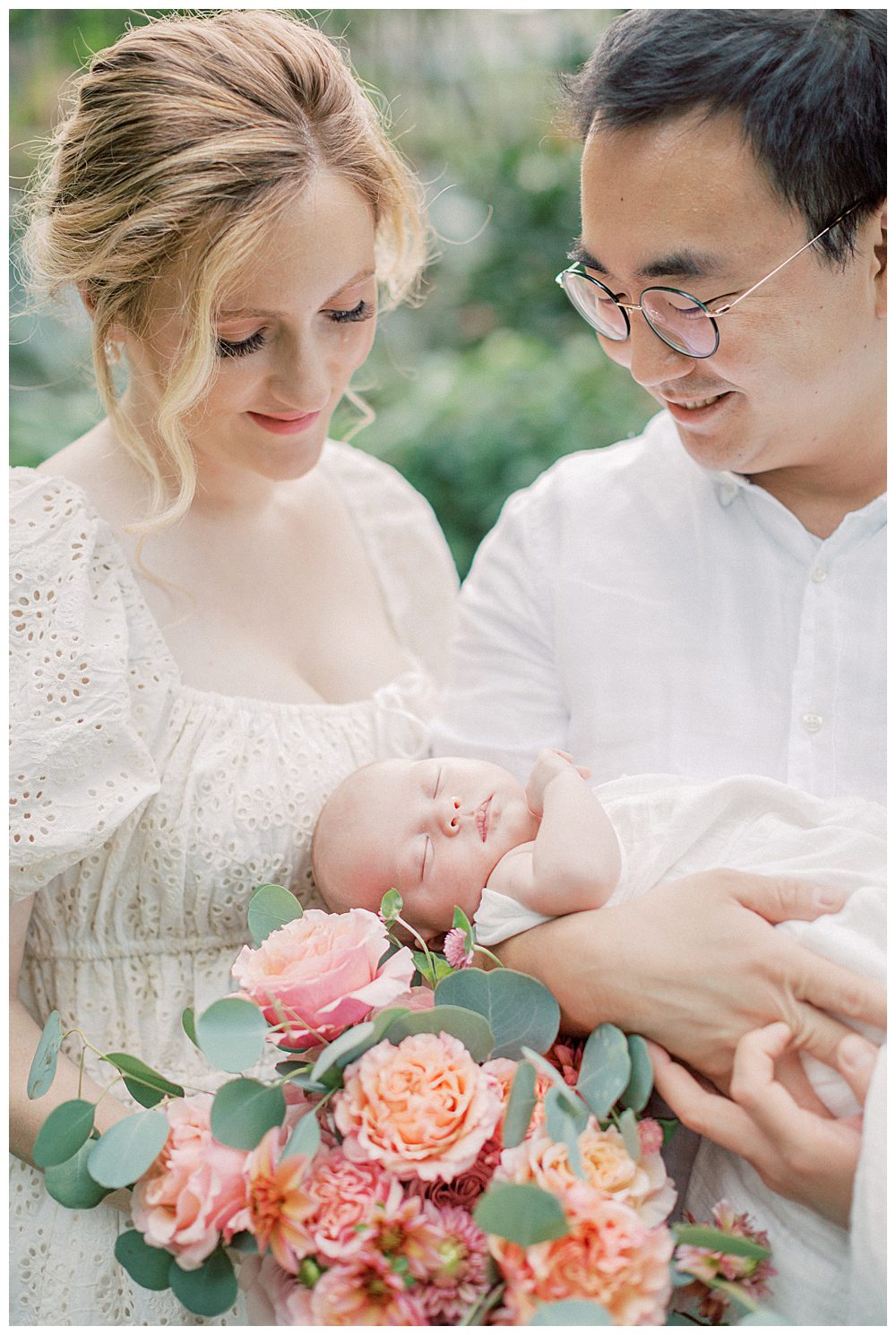 Newborn baby held on bouquet of roses by parents during Alexandria VA newborn session.