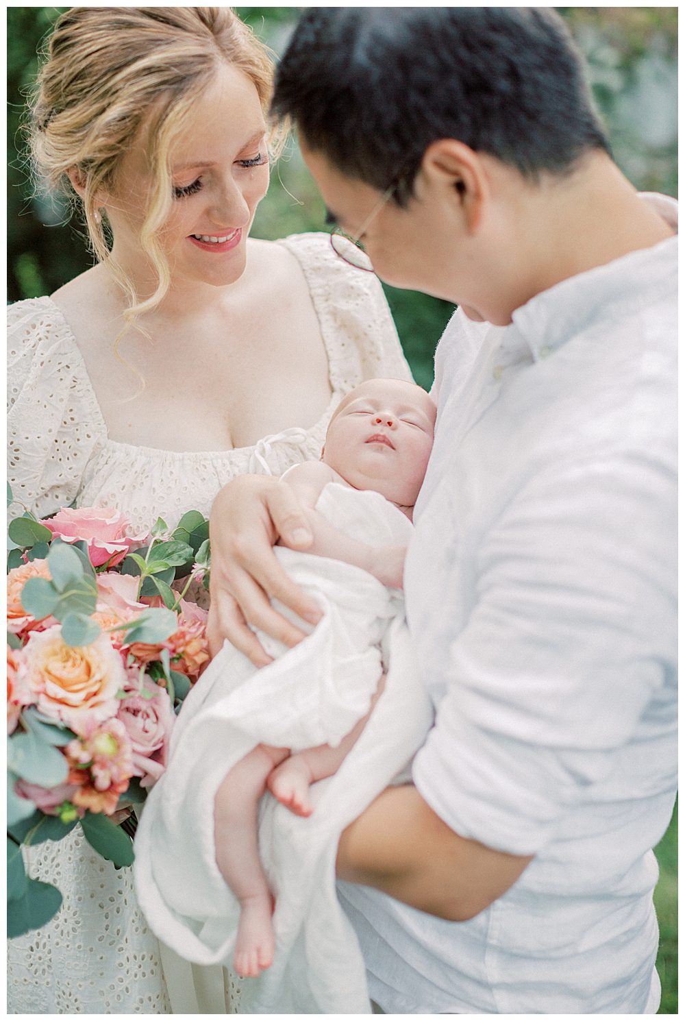 Parents hold their newborn daughter and roses during outdoor Alexandria VA newborn session.