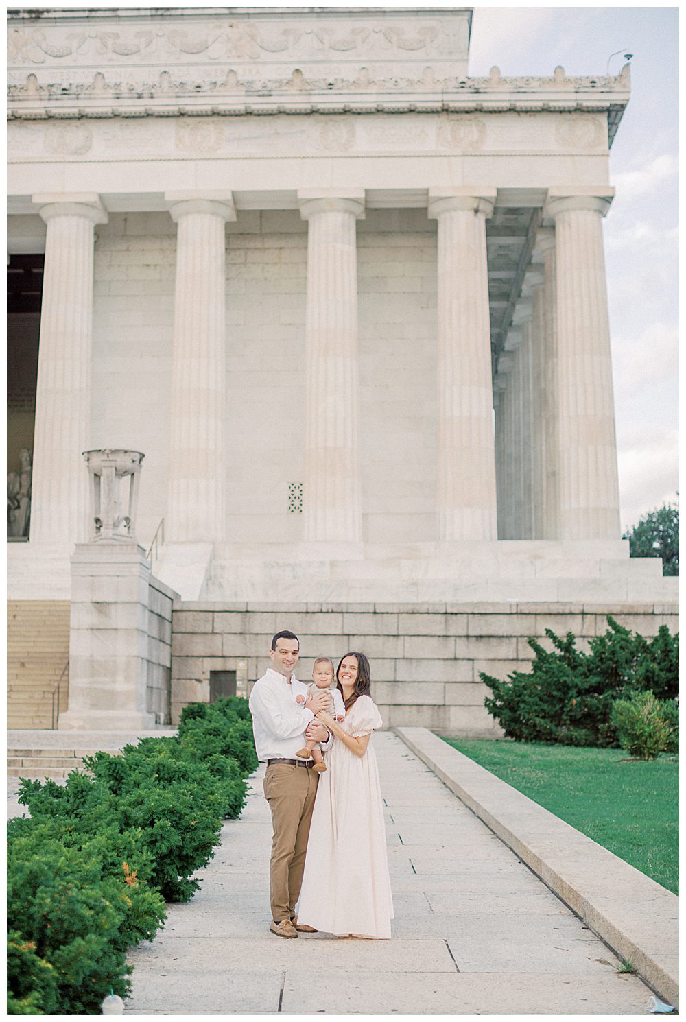 Mother, father, and toddler son stand in front of the Lincoln Memorial during DC Monuments Family Photo Session.