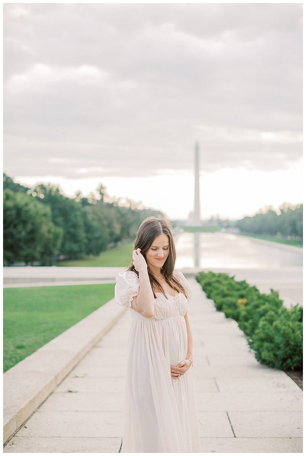 Pregnant mother holds belly during DC family photo session at memorials.