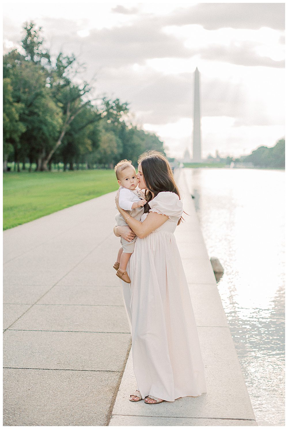 Mother kisses toddler son's cheeks during DC Monuments Family Photo Session.