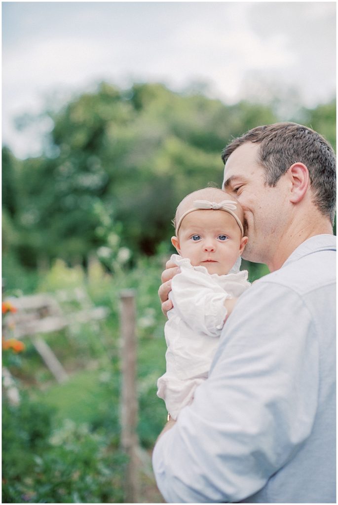 Father kisses baby girl on the side of her head during their Richmond family session.