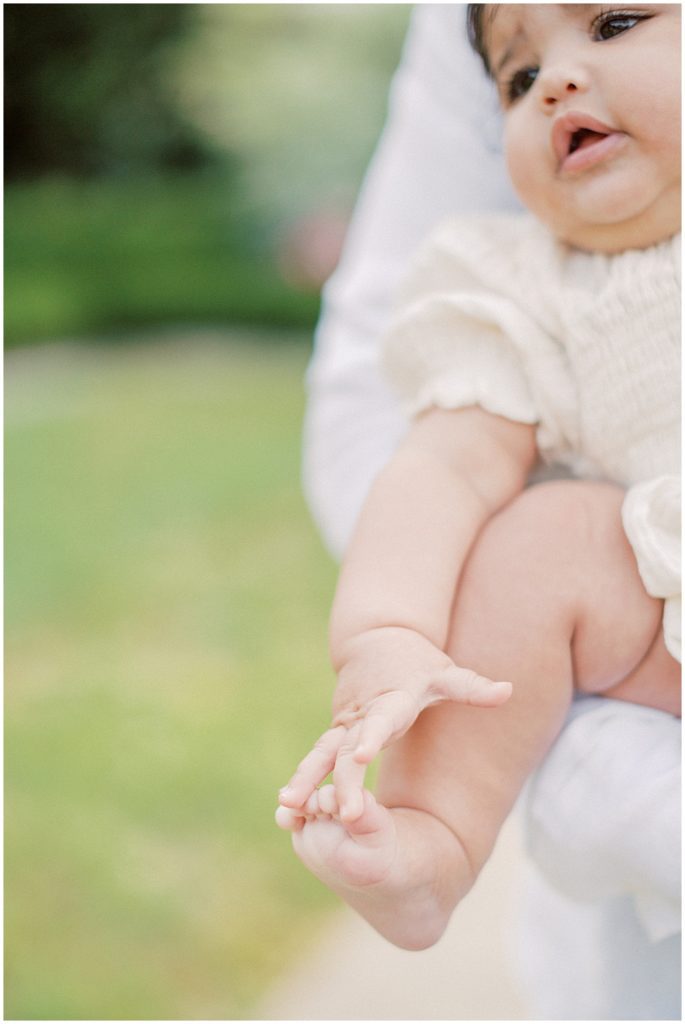 Baby girl touches her toes.