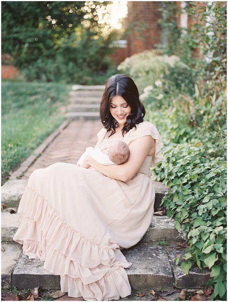 Mom sits on brick steps in gardens at Oatlands Historic Home during newborn session by Loudoun County Newborn Photographer Marie Elizabeth Photography.