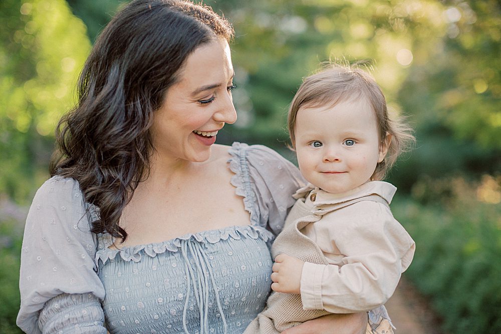 Toddler boy smiles at camera while held by his mother photographed by Georgetown Family Photographer Marie Elizabeth Photography.