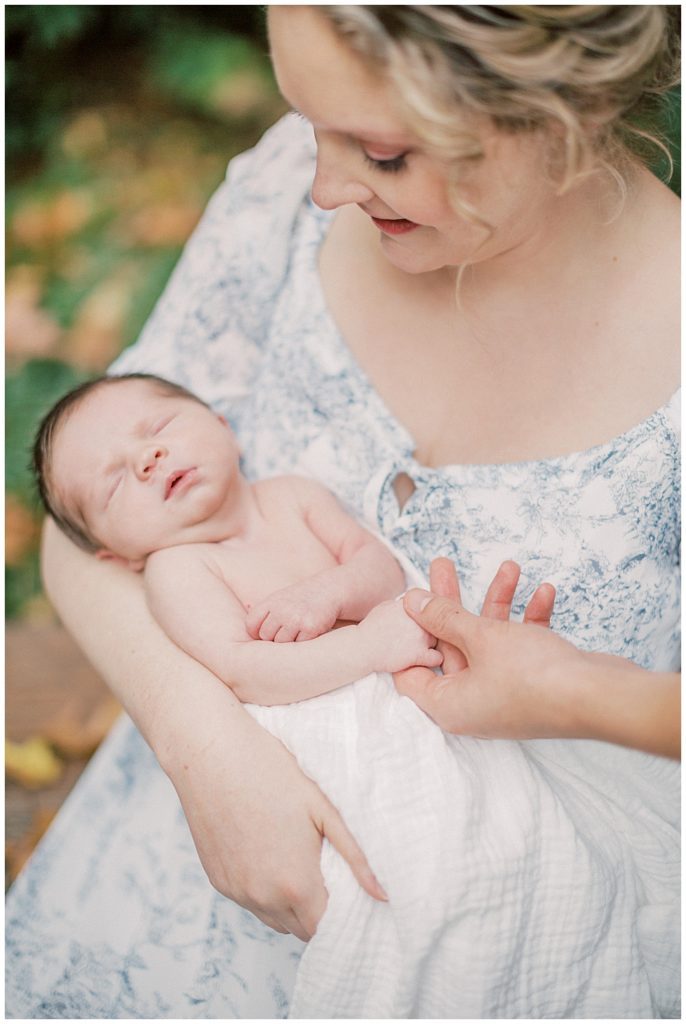 Mother holds baby girl on her porch during Fairfax VA newborn session.