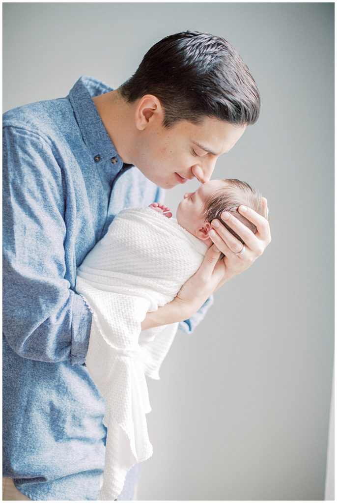 Father brings newborn daughter up to nuzzle during Fairfax VA newborn session.