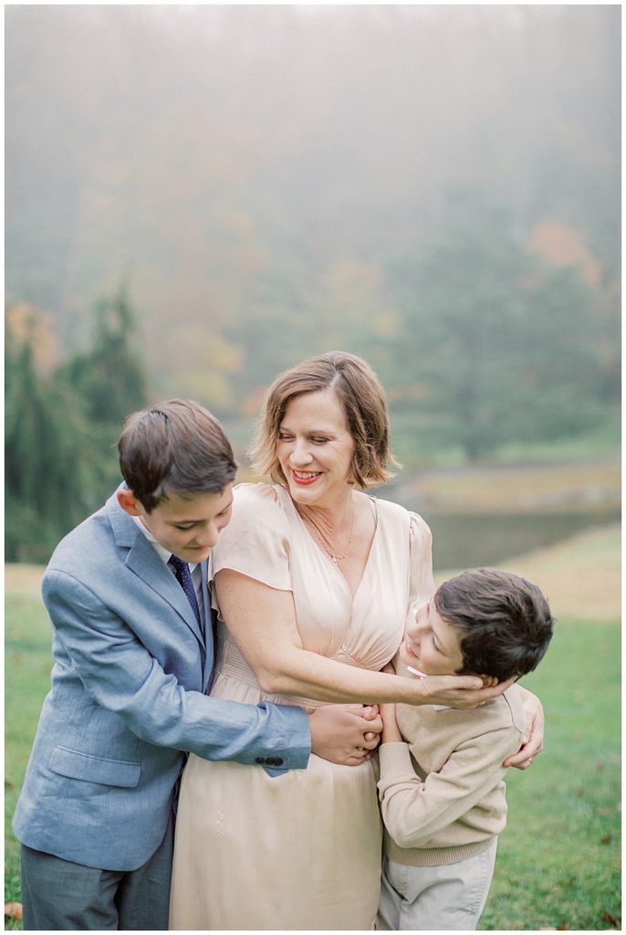 Mother embraces her two sons during their family session with older children at Brookside Gardens.
