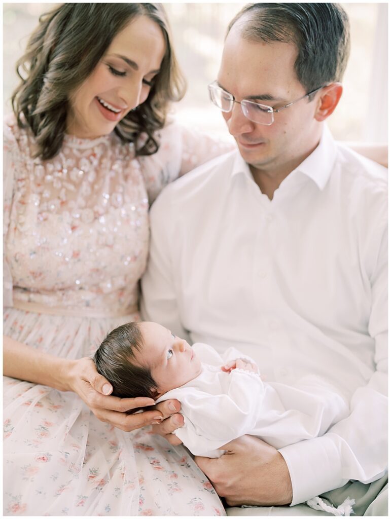 Mother and father gaze down at their baby girl during their Northern Virginia newborn session.
