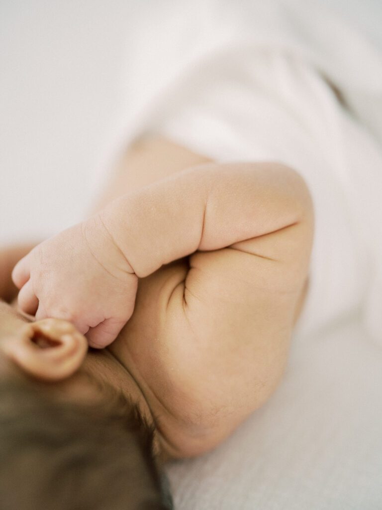 Close-up view of arm creases and dimples in newborn baby boy.