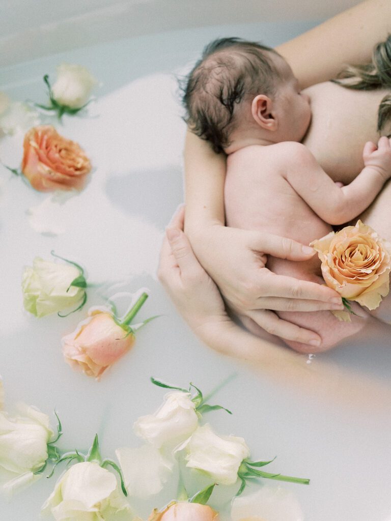 Milk bath photoshoots with a newborn baby girl and soft pastel florals.